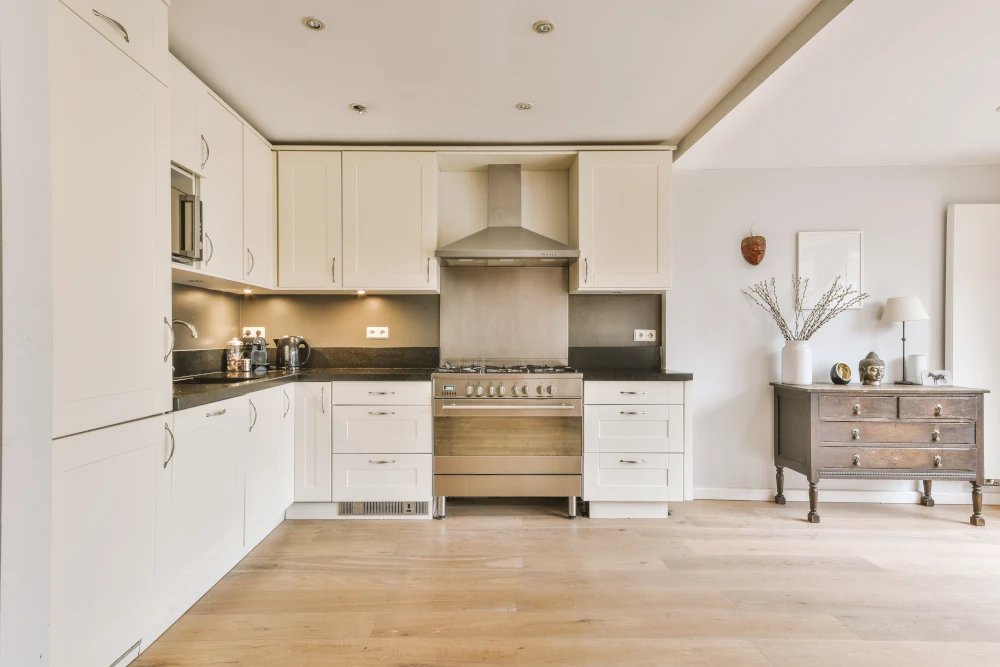 Hardwood flooring installed in a kitchen with white cabinets