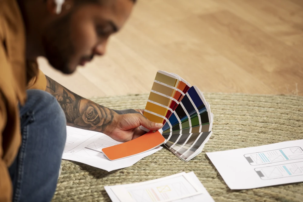 Man working on the floor and choosing paint colors for his sustainable home expansion