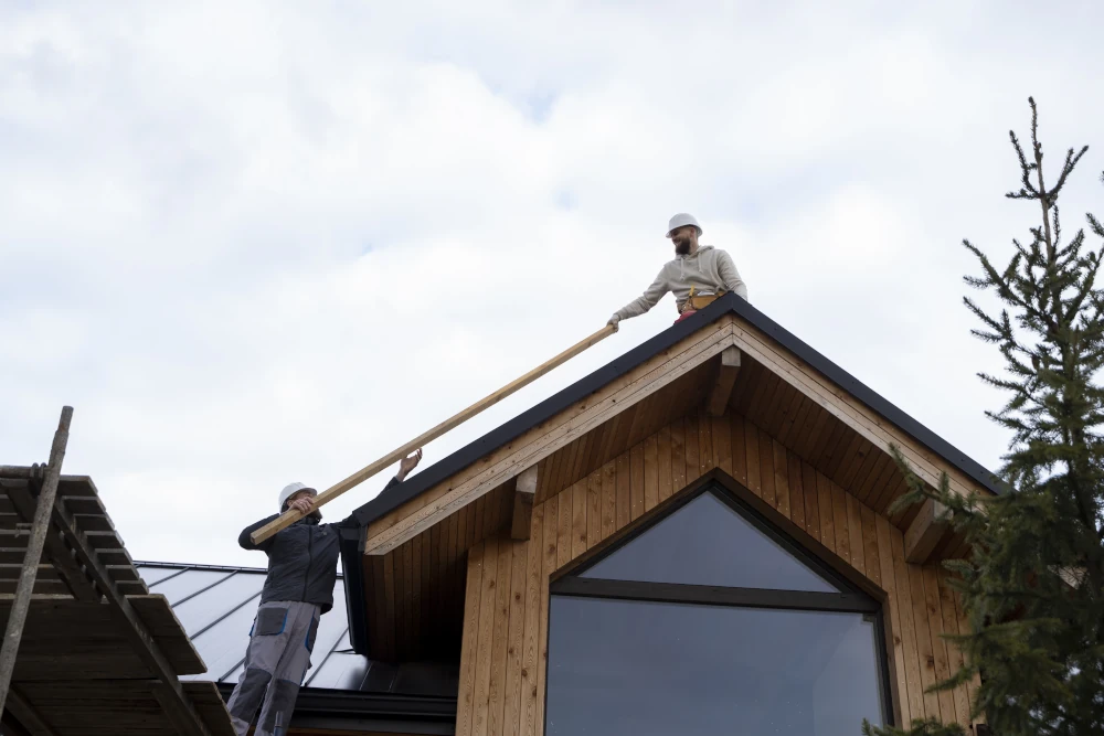 Carpenters working on the roof of a home expansion, representing the importance of choosing the right contractor to carry out the construction or renovation of your home.
