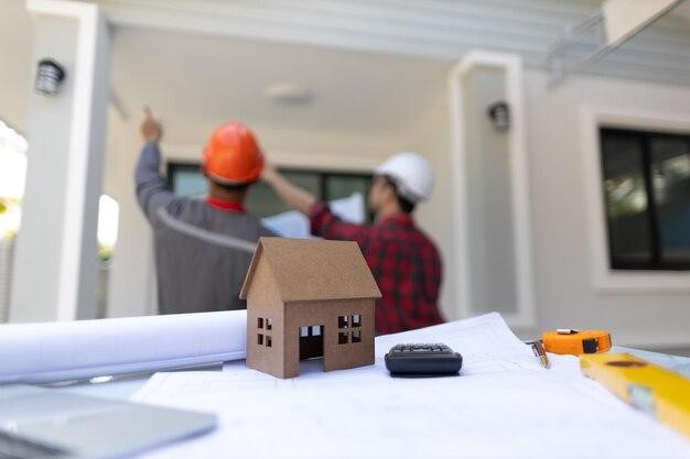 Two workers from a construction company analyze a renovation project, representing the importance of knowing how to flip houses.