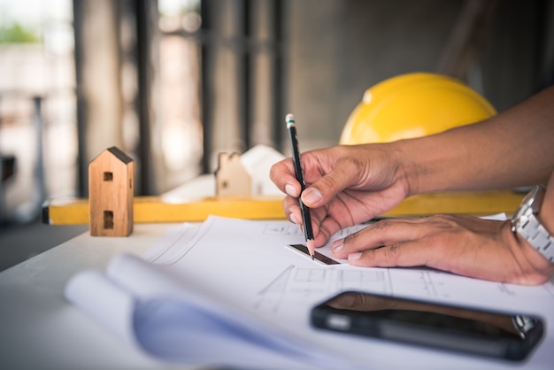 Construction contractor working on project plans and site inspections, ensuring compliance with commercial construction permits.