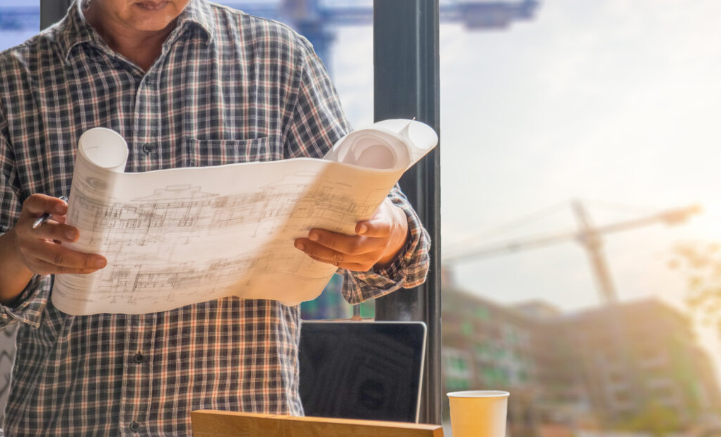 Business owner checking commercial construction permit on paper.