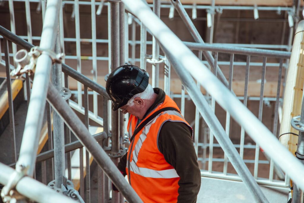 Man standing on scaffolding, representing the importance of effective pre-construction planning.