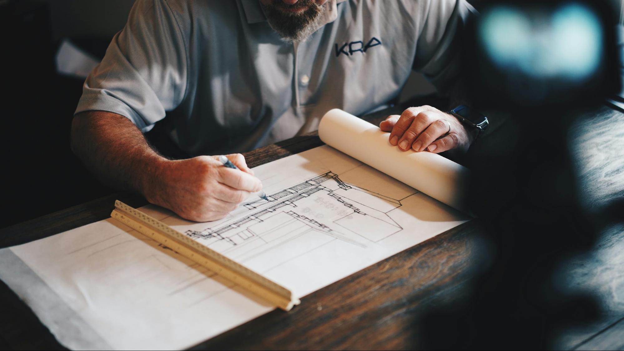 Commercial construction contractor working on pre-construction planning with a pencil and ruler